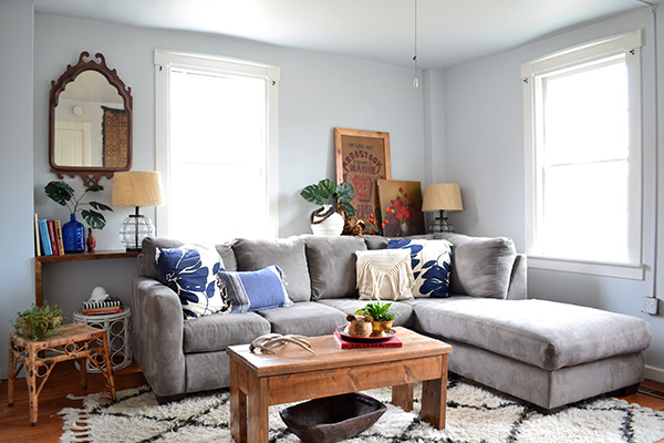 Light blue living room with gray couch and bohemian accents in a farmhouse renovation