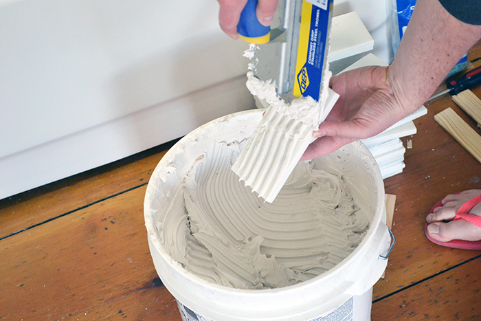 Back butter marble subway tiles for less mess when tiling in a bathroom