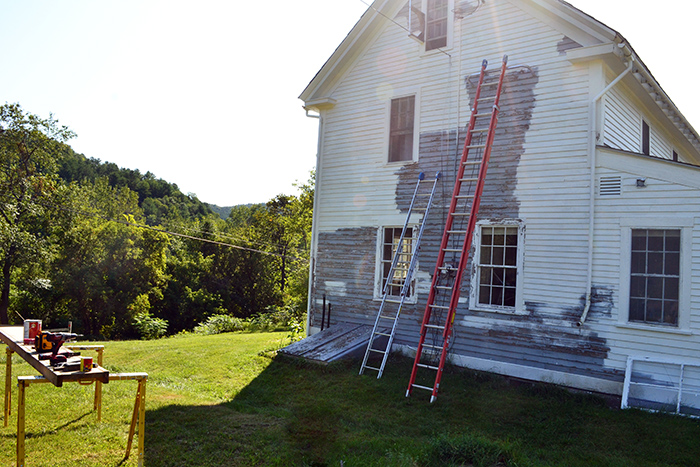 Scraping and painting the exterior of an old colonial farmhouse