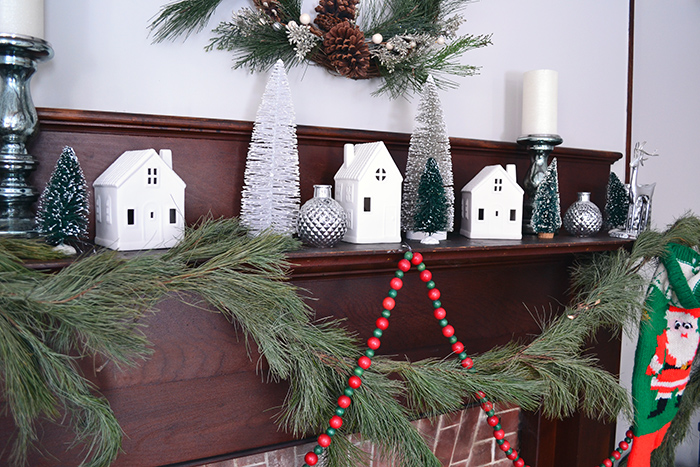 Simple Christmas decor featuring vintage wood beads, pine swag, and Target ceramic houses