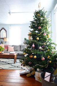Christmas tree decorated with natural wood beads and gold and pink ornaments