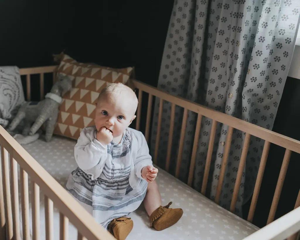 Family and baby photos taken in a dark and moody nursery, baby pictured in her crib