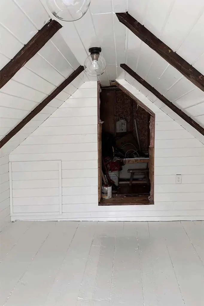 Finished attic space with v-groove pine boards, access panel to crawl spaces