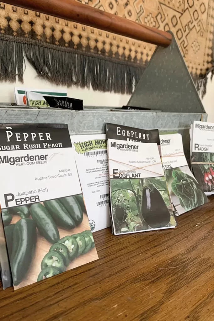 Organizing seed packets by vegetable type to prepare for creating a vegetable garden plan