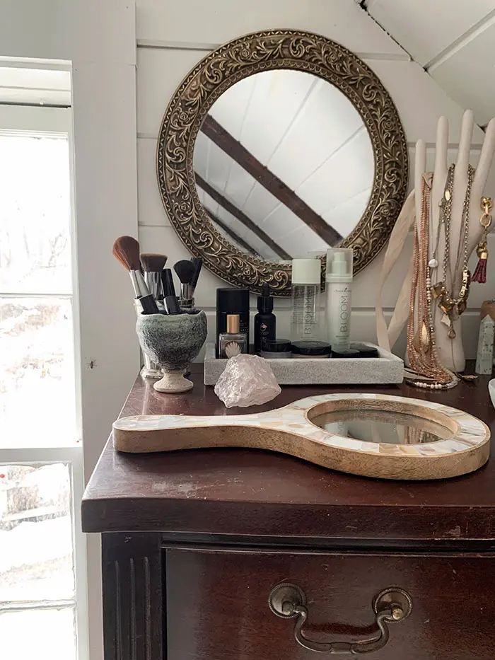 A dresser top turned into a vanity for getting ready in an attic walk-in closet