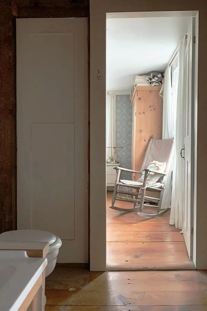 Small bathroom under construction, view from the bathroom into the primary bedroom