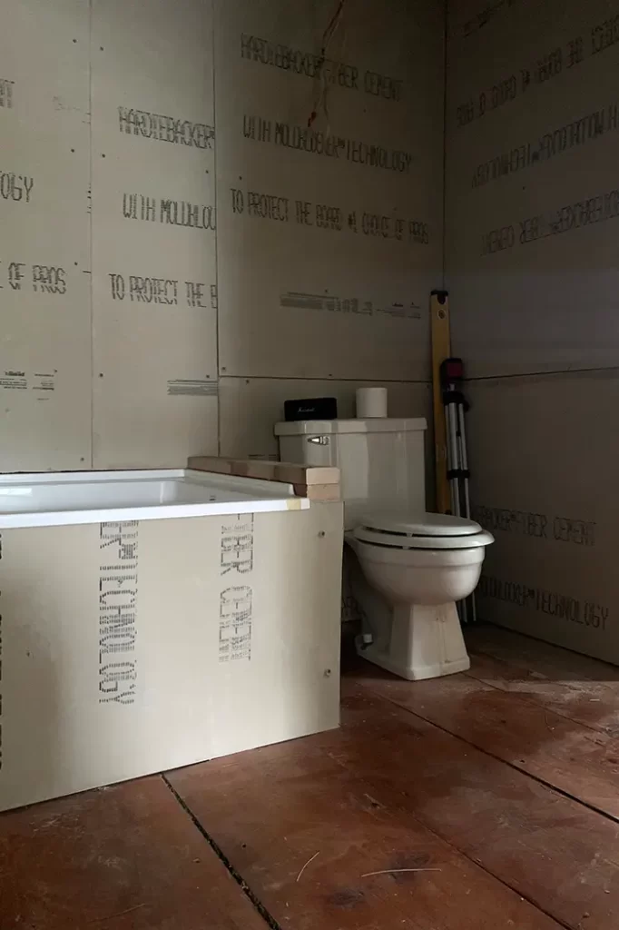 Installing cement board in a bathroom to prep the walls for tiling