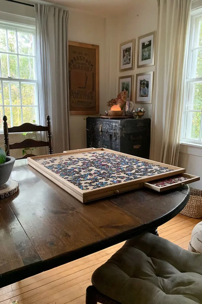 Vintage trunk in a dining room used for puzzle storage, puzzle board on dining room table