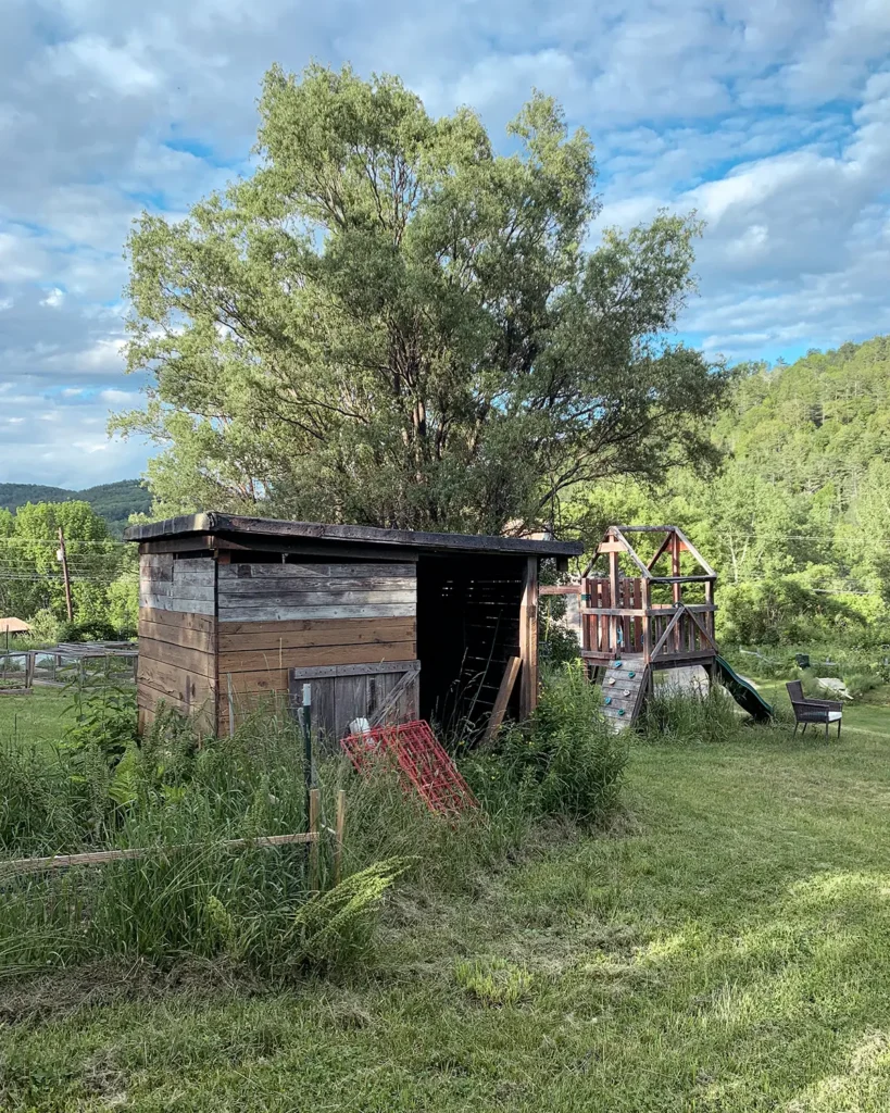 Old garden shed with a compost pile next to it