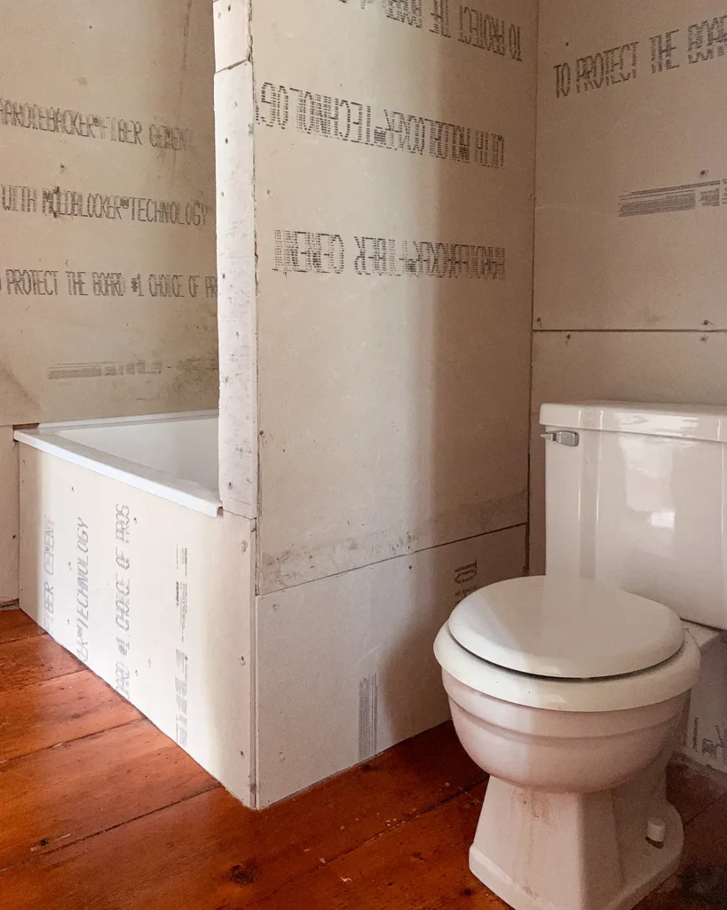 DIY shower surround and wall to enclose a bathtub/shower combo and create a toilet nook, prepped for tiling with cement board installed