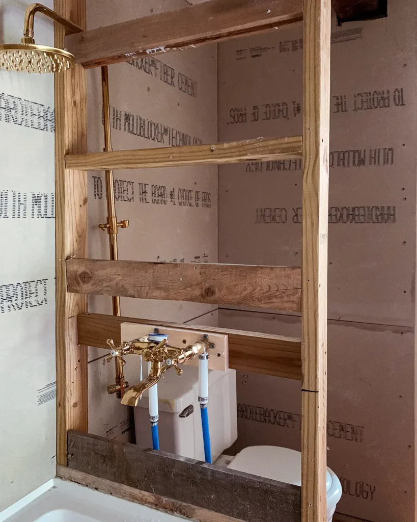 Framing nailers in a DIY bathroom wall to support the structure and the shower plumbing