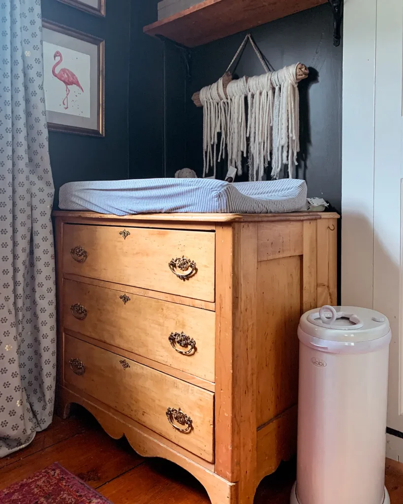 Vintage nursery dresser with changing pad and a white Ubi diaper pail beside it