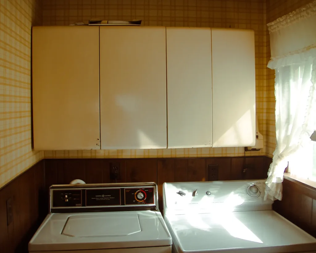 Old, metal laundry room upper cabinets in the laundry room before photo