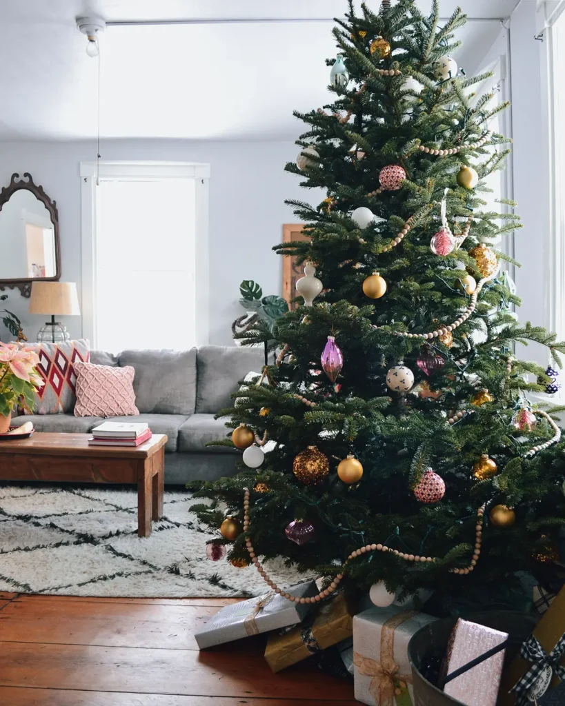 Vermont farmhouse decked out for Christmas with a simple Christmas tree in the living room and gifts in an old metal wash bin