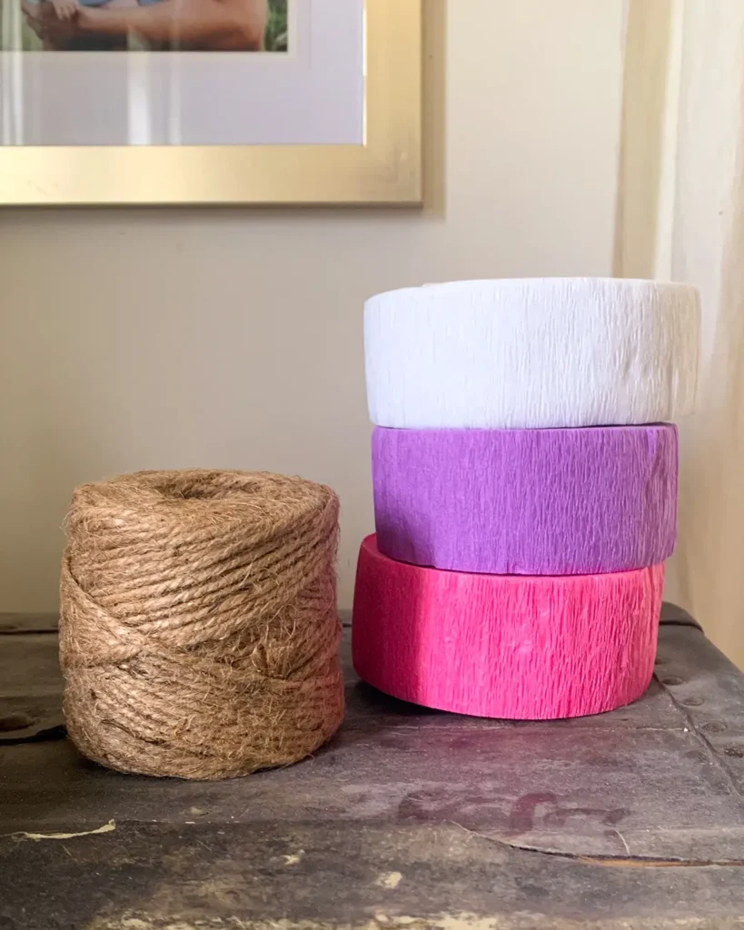 DIY crepe paper bunting making supplies include jute and a few rolls of crepe paper streamers