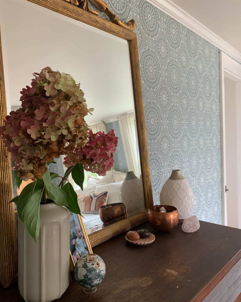 Basic styling the top of your dresser with flowers from the yard, vintage mirror, crystal collection, and a family photo