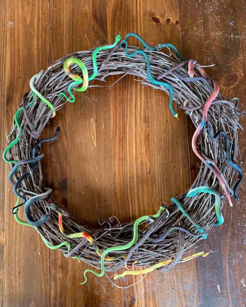 Arranging colorful rubber snakes on a grapevine wreath