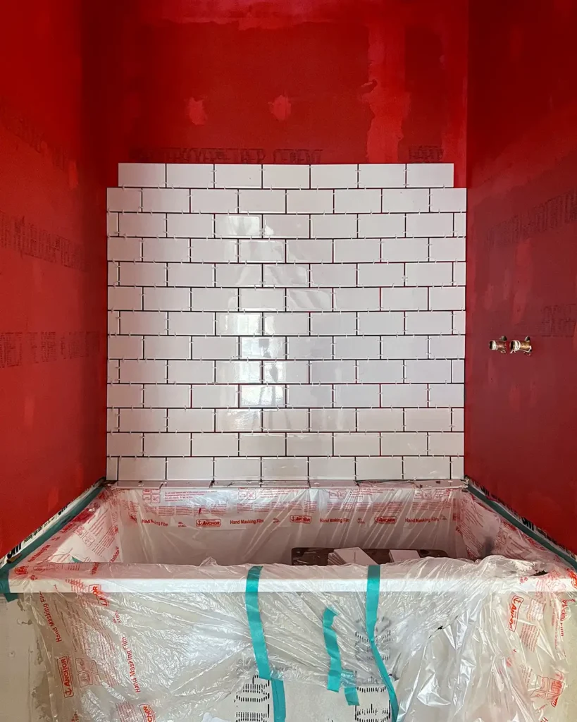 Shower tiling progress day one installing white subway tile surrounding tub