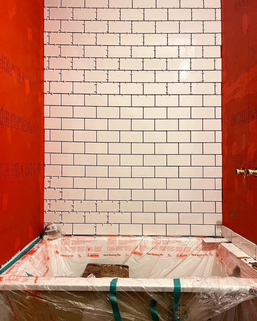 Shower tiling day 2 progress installing white subway tile in a shower