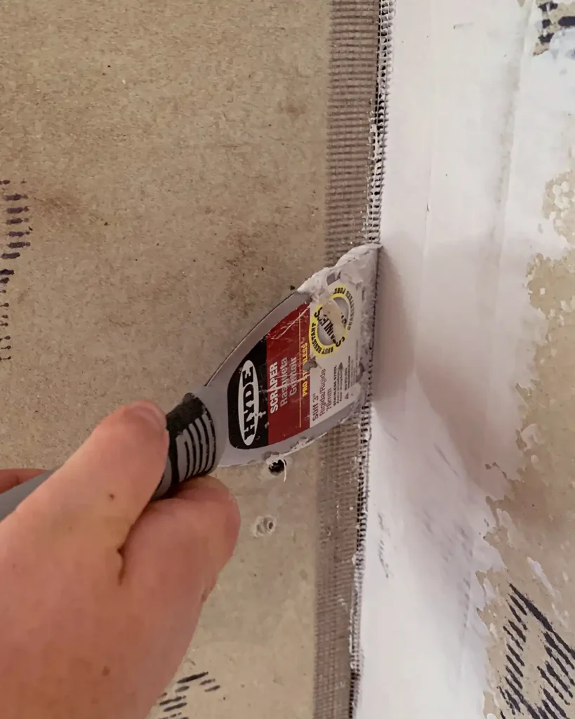 Applying thinset mortar to cement board joints using a putty knife