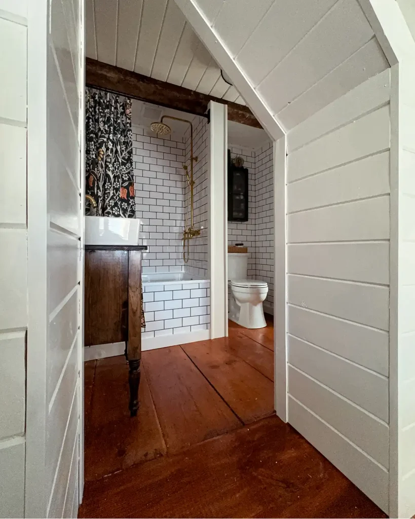 V-groove planked doorway from the attic walk-in closet to the bathroom with vintage wide pine floorboards