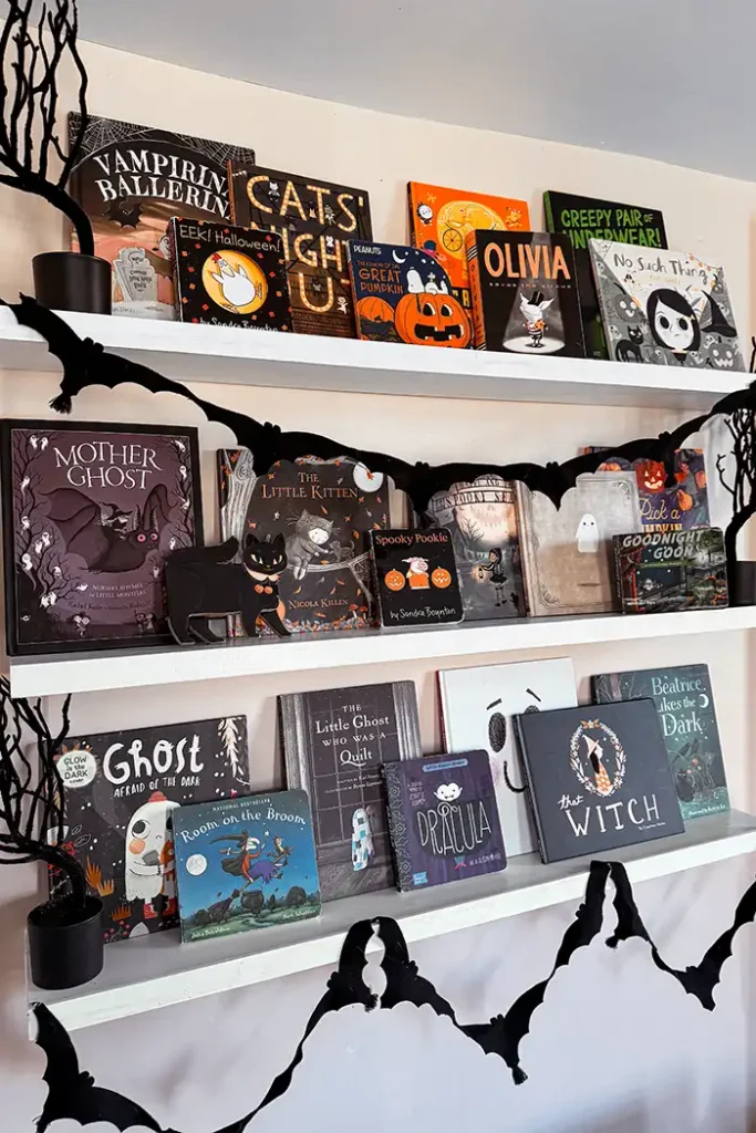 Halloween books for kids collection displayed on open bookshelves decorated for Halloween