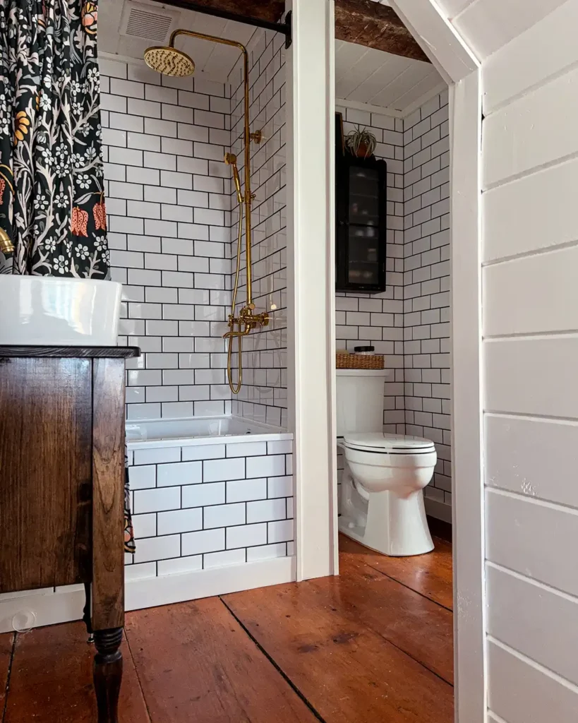 Small bathroom remodel with white subway tile, black grout, wide pine floors, dark wood vanity, and white trim painted Benjamin Moore White Dove