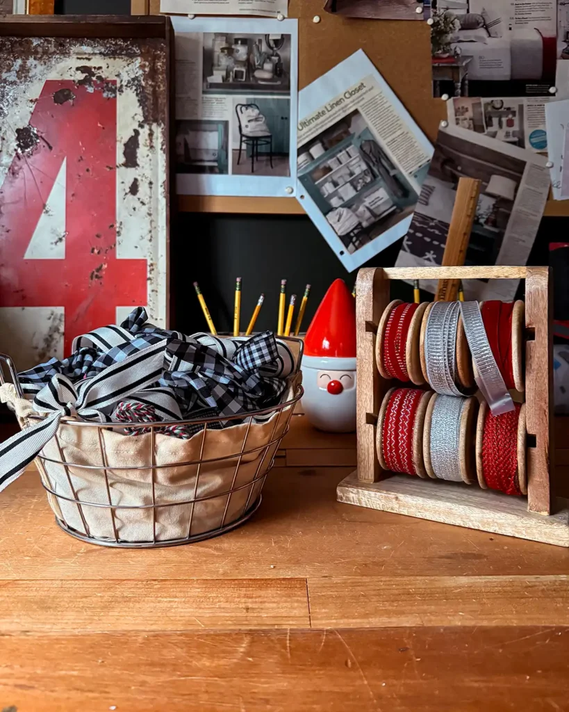 A basket of recycled ribbon and spools of red and silver ribbon on a ribbon rack