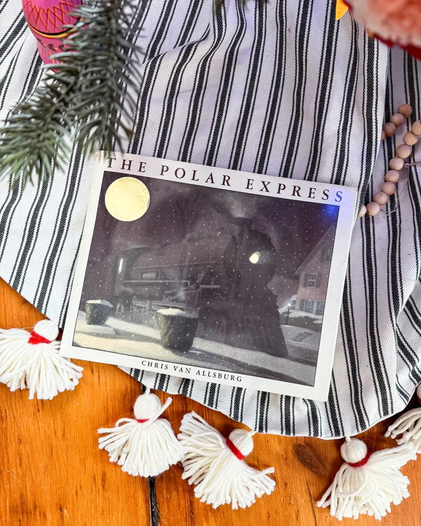 The Polar Express vintage Christmas picture book on a tree skirt underneath a Christmas tree