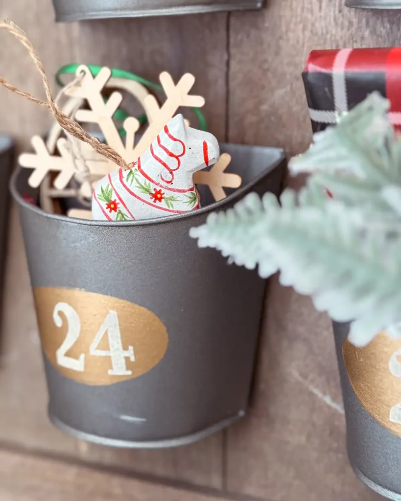 Wooden horse and snowflake ornaments in a galvanized advent calendar from Pottery Barn