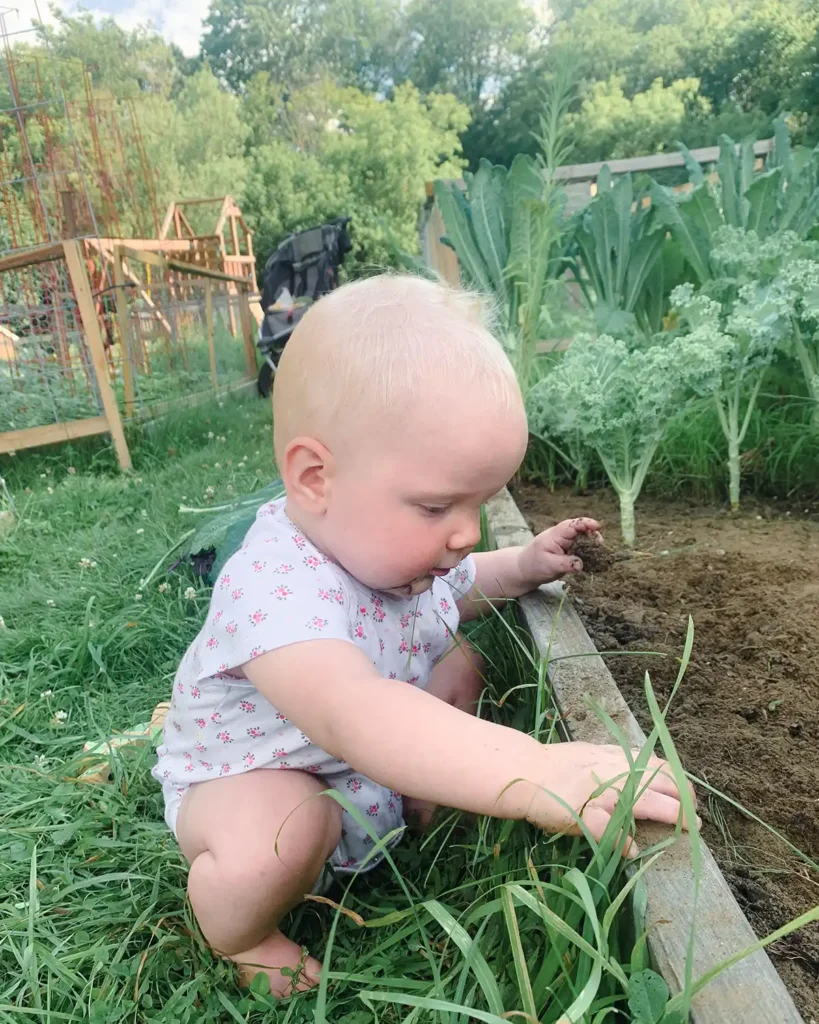 Gardening with kids and tending the kale raised garden bed with a baby