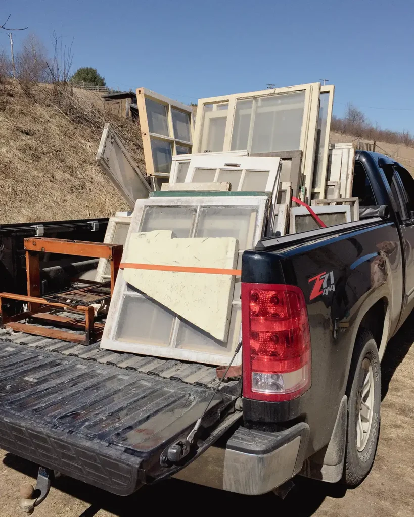 Truck load of old windows that were destined for the dumpster saved to use for our window greenhouse construction plans