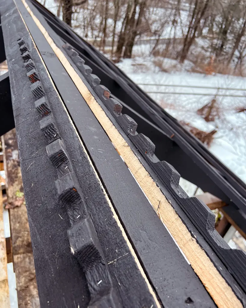 Wood closure strips installed near the ridge of the greenhouse roof