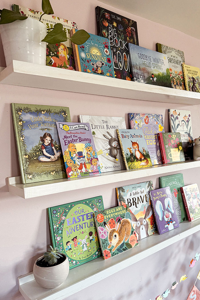 Spring and Easter books for kids featured image with all kinds of seasonal picture books on open bookshelves decorated with plants and spring banners