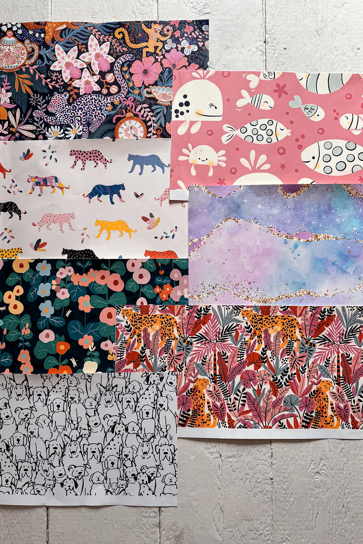 Bedroom wallpaper ideas featured image with a selection of wallpaper samples for a kids bedroom laid out on the floor