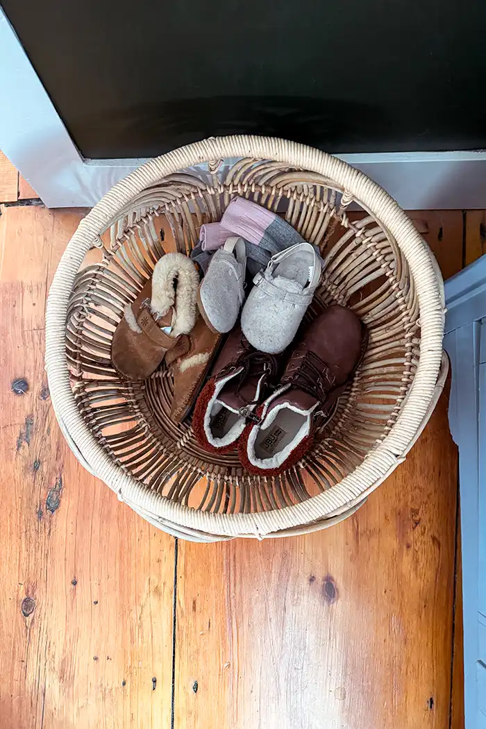 Declutter challenge end featured image with a basket corralling donations including a pair of women's boots and some kids' slippers