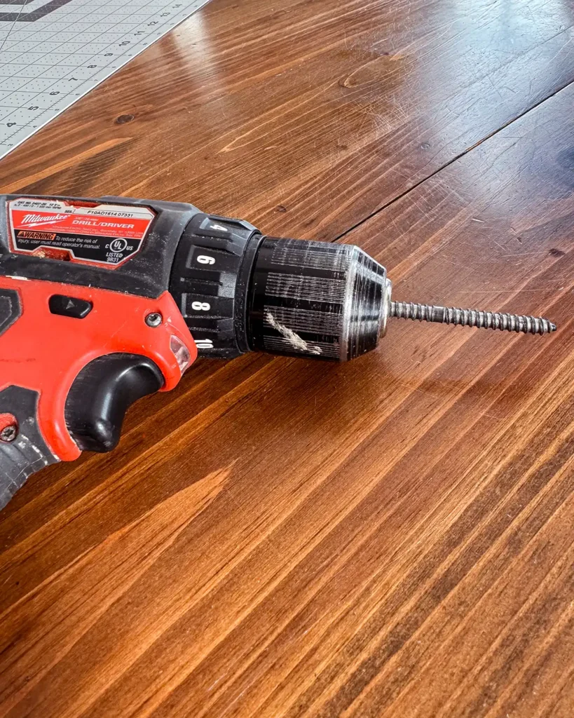 Attaching dowel screw to a cordless drill before screwing it into a dowel