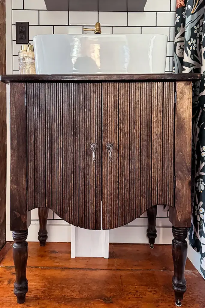DIY bathroom vanity featured image with a vanity designed to look like the Arhaus Conrad line of furniture with a white vessel sink on top