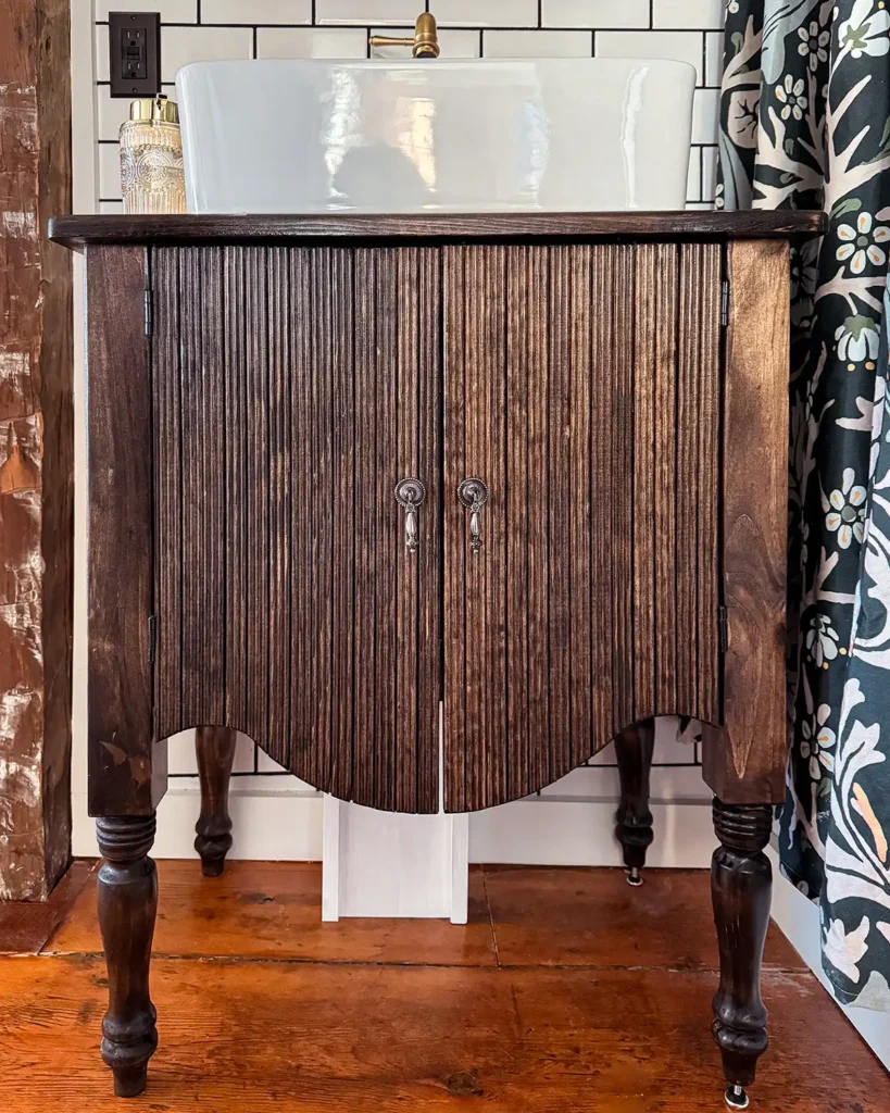 A DIY bathroom vanity for a small space, custom built to look like Arhaus Conrad furniture, stained dark with a white vessel sink on top