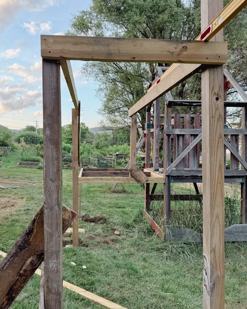 Framing playground additions including extending a deck and adding monkey bars off the side of the new deck extension, framing using 4" x 4" posts
