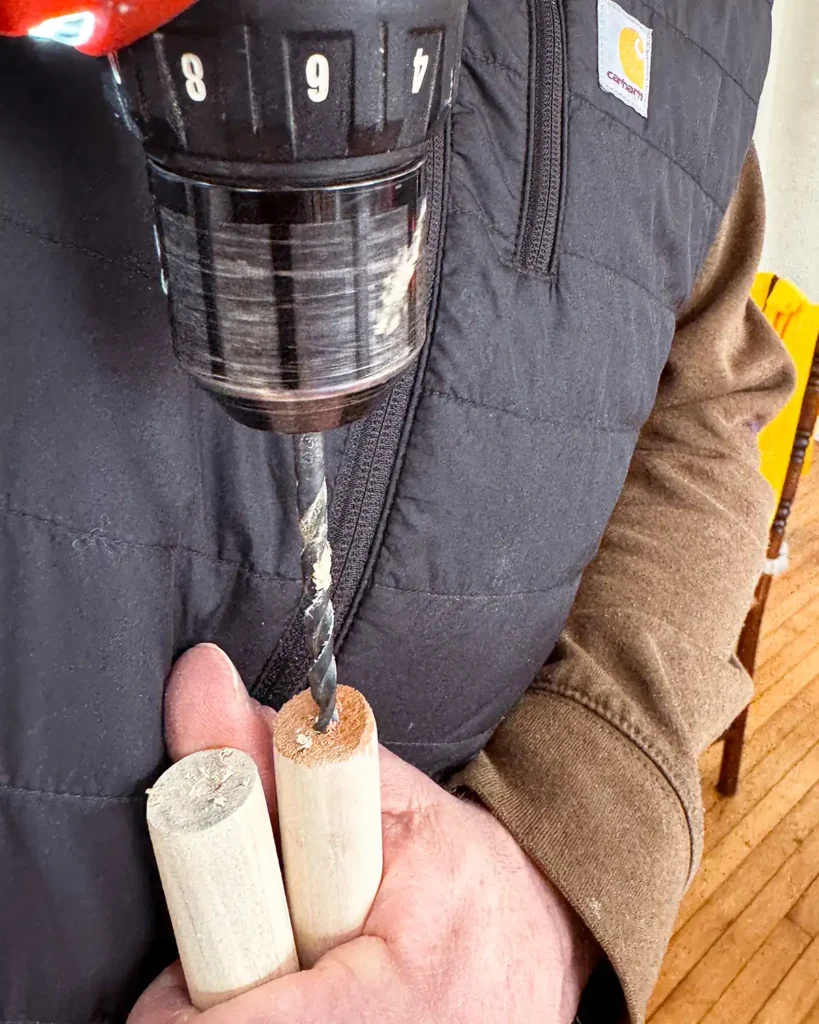 Pre-drill holes into the end of the dowels using a cordless drill to attach the two dowels together