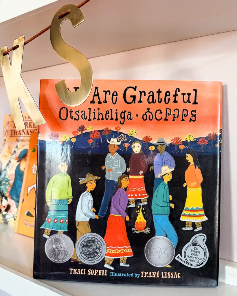 We Are Grateful: Ostalieheliga kids' book sitting on a child's bookshelf