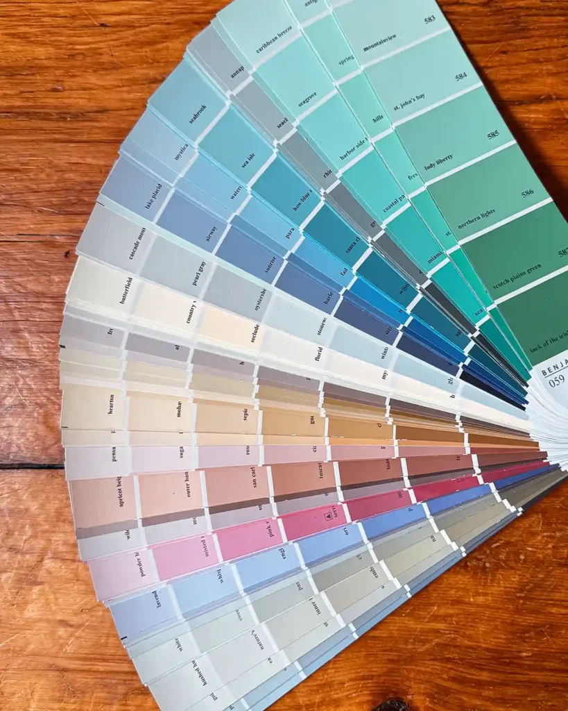 Fanned out paint color swatches from Benjamin Moore sitting on a floor
