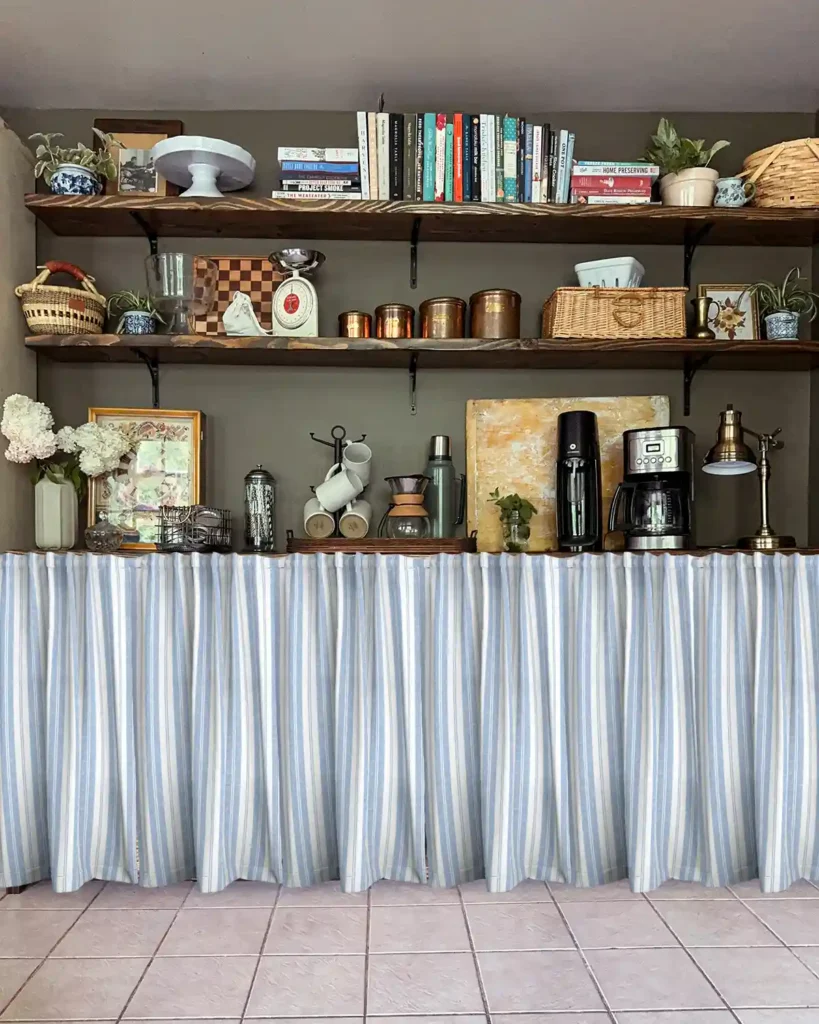 Vintage French blue stripe ticking patterned cafe curtains Photoshopped hanging in front of lower kitchen pantry shelves with open shelves style and full of kitchen supplies above