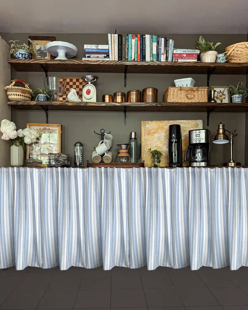 A kitchen pantry area with dark, charcoal painted floors and Photoshopped light blue striped curtains hanging in front of lower pantry shelves with open shelving above