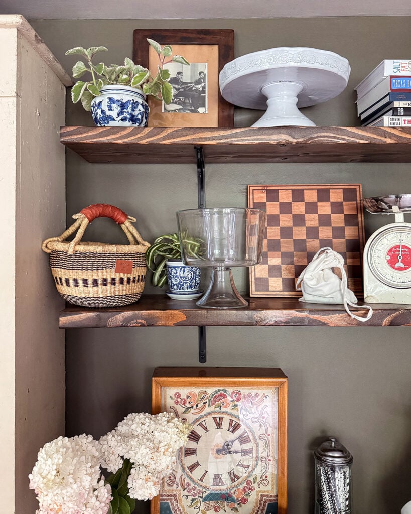 DIY open kitchen pantry shelves made from thick, framing lumber and basic black shelf brackets decorated with kitchen items and vintage decor