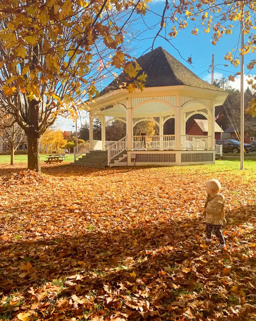 Leaf peeping at a town green with a large gazebo and fall foliage, part of our fall bucket list