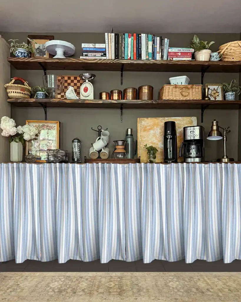 A kitchen pantry zone with a light patterned rug and blue striped curtains Photoshopped in, open shelves for storage hang on the wall above