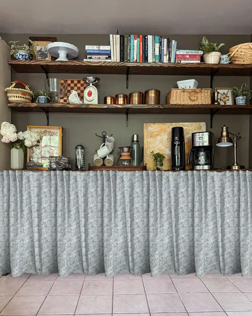 A light blue floral patterned fabric as cafe curtains Photoshopped over lower kitchen pantry shelves with open shelves for storage above