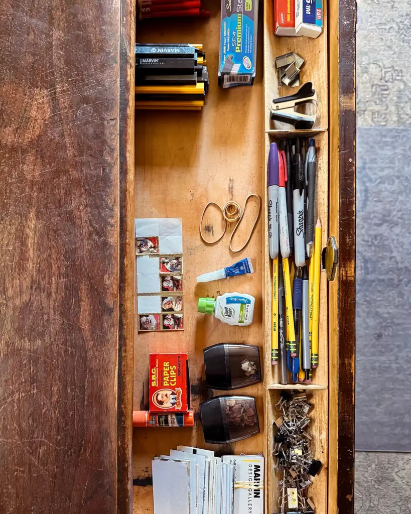 A top desk drawer in a home office after decluttering and returning all the office supplies to the drawer